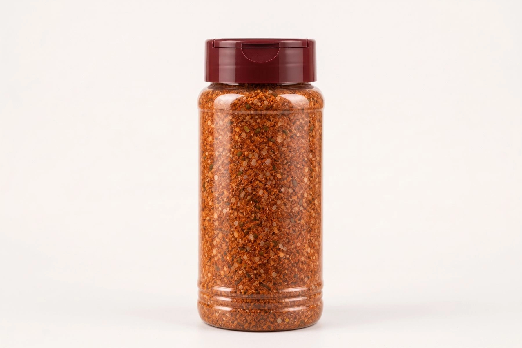 Clear cylindrical BBQ rub spice bottle with a closed burgundy cap