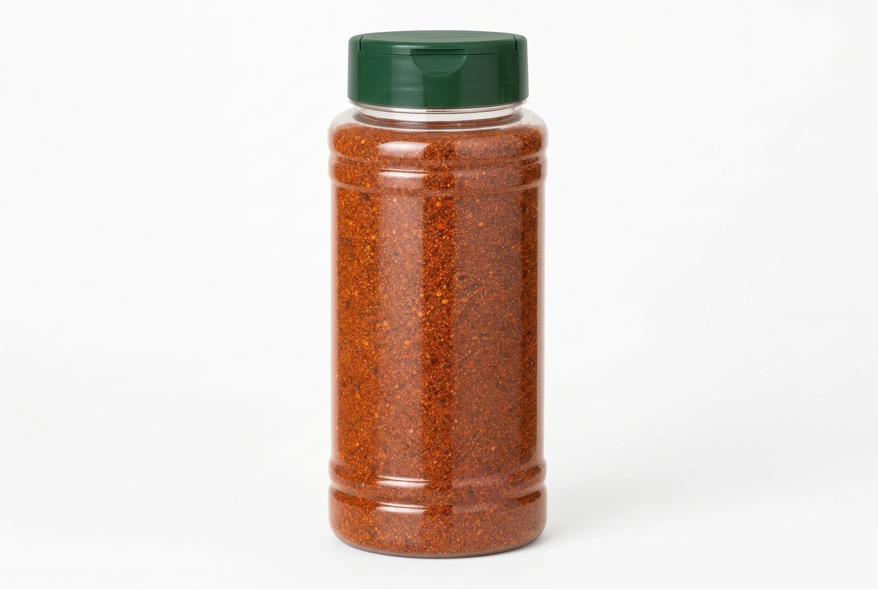 Large clear foodservice seasoning bottle filled with spice blend and fitted with a green cap